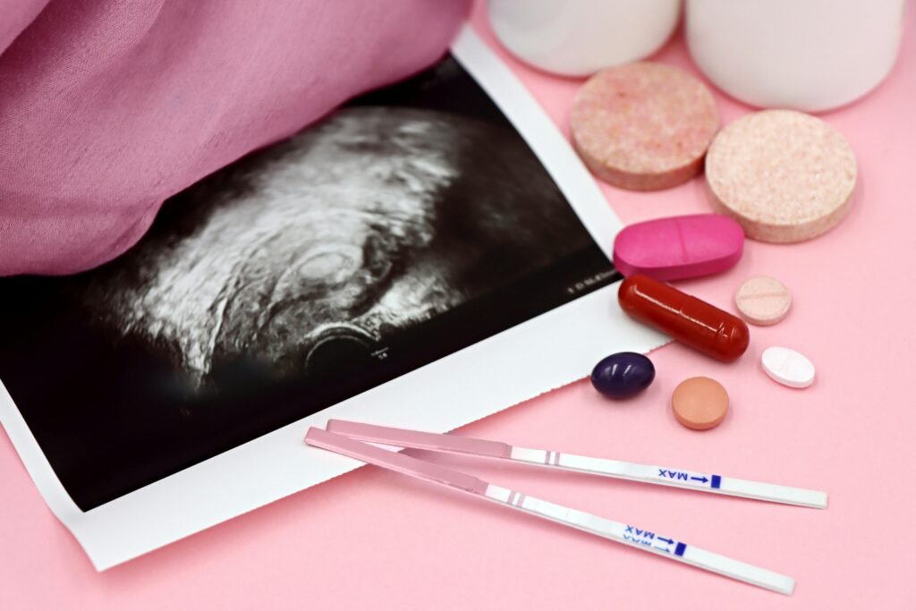 pexels photo 29027953 29027953 A closeup of pregnancy tests and an ultrasound with supplements on a pink background.