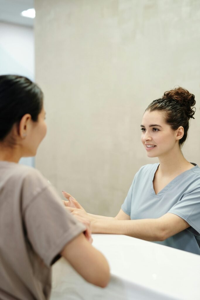 pexels photo 4269202 4269202 Nurse in conversation with patient at a medical reception desk, emphasizing care and support.