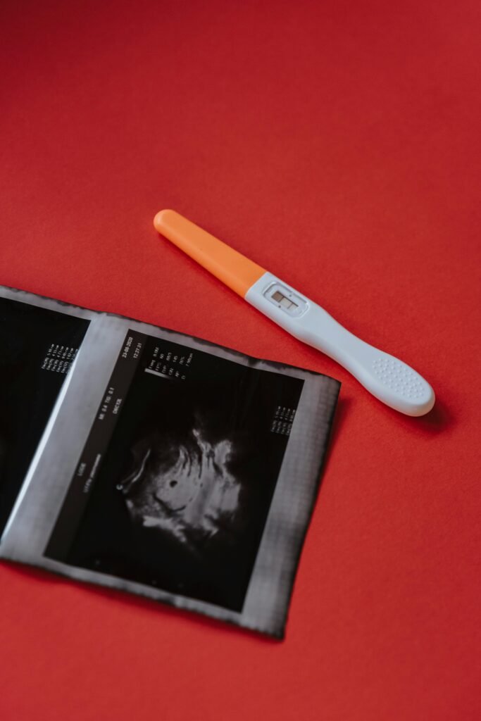 pexels photo 5974437 5974437 A positive pregnancy test alongside an ultrasound image on a vibrant red background.